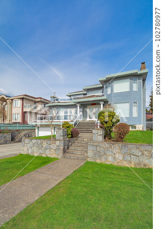 Luxury residential houses with landscaped front yard on land terrace 102780977