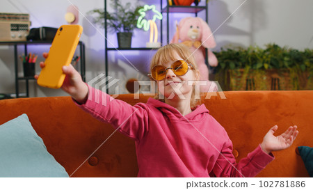 Child kid girl taking selfie on smartphone communicating video call home online with subscribers Child kid girl taking selfie on smartphone communicating video call home online with subscribers 102781886