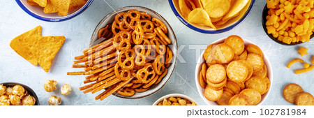 Salty snacks, party mix panorama. An assortment of crispy appetizers 102781984