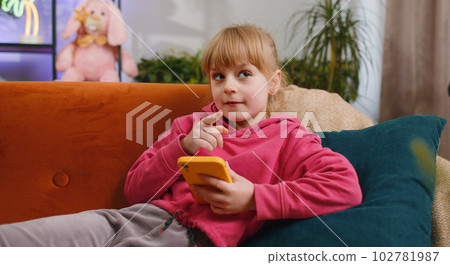 Young child kid girl texting messages on smartphone social media app, online shopping, play game 102781987