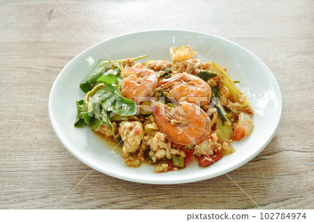 spicy chili stir fried mashed chicken and shrimp with basil leaf on plate spicy chili stir fried mashed chicken and shrimp with basil leaf on plate 102784974