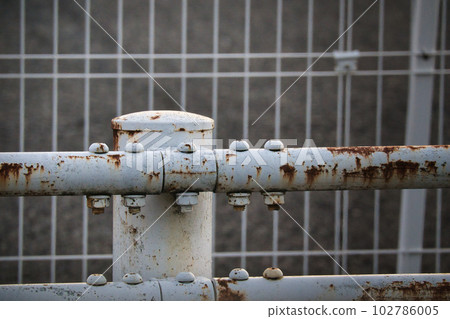 An old rusty guardrail that protects pedestrians 102786005