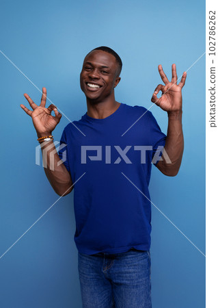 cheerful young american man in blue t-shirt gesturing 102786262
