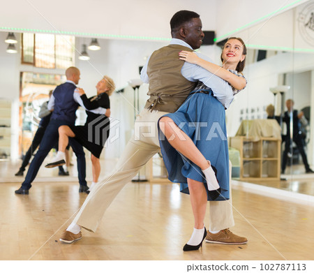 Woman with american man practising ballroom dancing 102787113