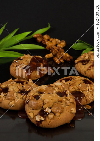 cookies with peanuts and caramel on a black background cookies with peanuts and caramel on a black background 102789326