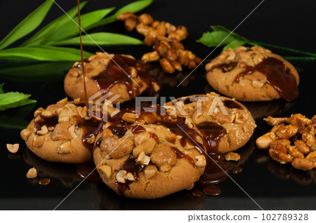cookies with peanuts and caramel on a black background cookies with peanuts and caramel on a black background 102789328