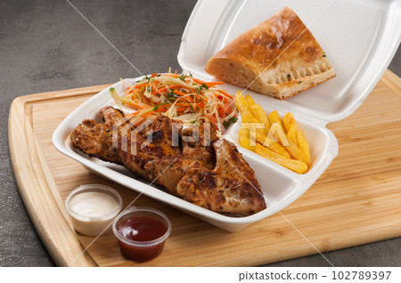 grilled chicken wings in a plastic container. concept grilled chicken wings in a plastic container. concept 102789397