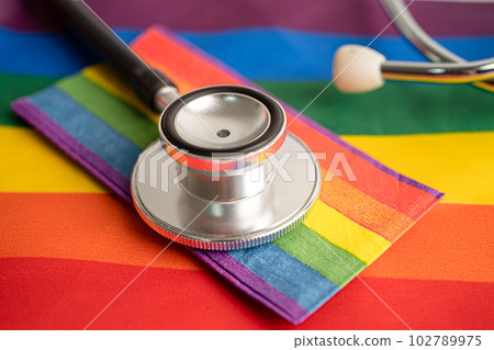 Black stethoscope on rainbow flag background, symbol of LGBT pride month celebrate annual in June social, symbol of gay, lesbian, bisexual, transgender, human rights and peace. 102789975