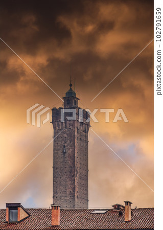 Bologna, Italy Asinelli Tower, part of Due Torri, medieval Two Towers city symbol, against dramatic orange clouds. 102791659