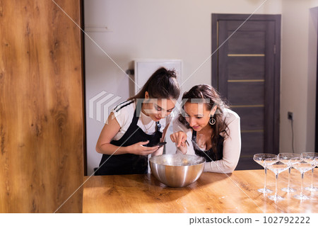 Two woman looks on Smoke vapor dry ice in bowl in kitchen 102792222