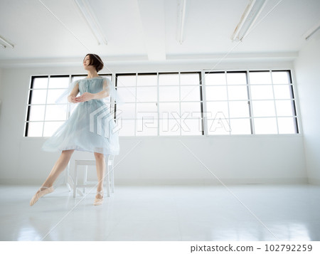 一個女人在有窗戶的明亮房間裡練習芭蕾舞 102792259