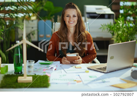 happy elegant business owner woman in green office 102792807