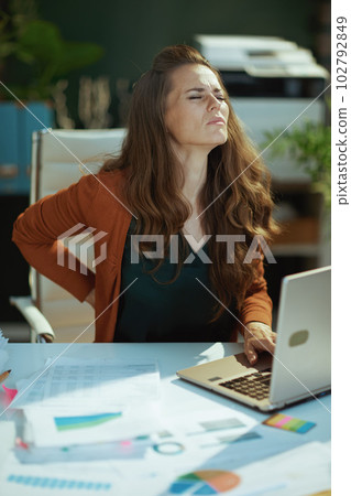 sad trendy 40 years old business owner woman in green office 102792849