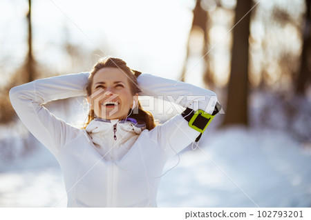 happy active woman in white jacket with headphones happy active woman in white jacket with headphones 102793201