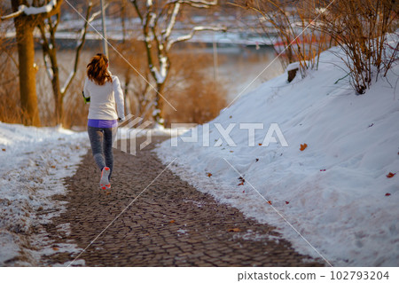 Full length portrait of active woman in white jacket running Full length portrait of active woman in white jacket running 102793204