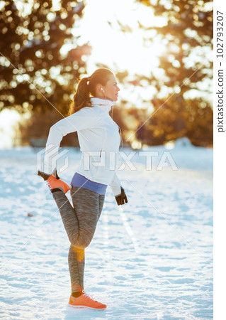 Full length portrait of fitness woman in jacket stretching 102793207