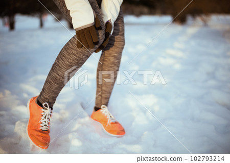 Closeup on woman in white jacket having leg pain 102793214