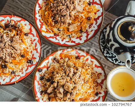 Plates with fragrant pilaf are on the table Plates with fragrant pilaf are on the table 102794767