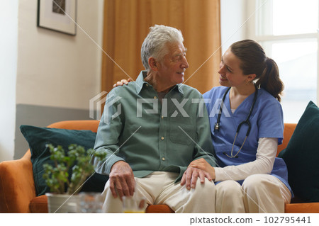 Young nurse checking elderly senior in his home. 102795441