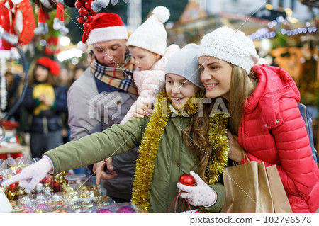 Woman with daughter choosing Christmas toys 102796578