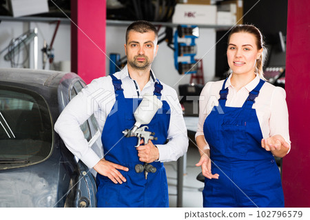 Two mechanics welcoming in car painting workshop 102796579