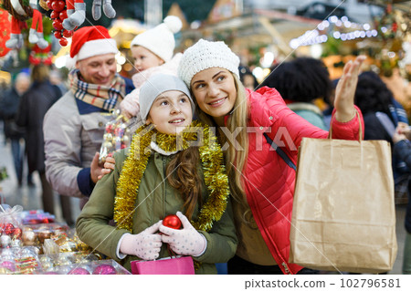 Woman with daughter choosing Christmas toys Woman with daughter choosing Christmas toys 102796581