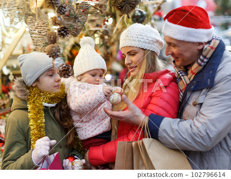 Parents with daughters choosing Christmas toys 102796614