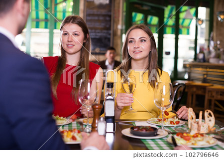 Smiling friends are drinking wine and eating 102796646