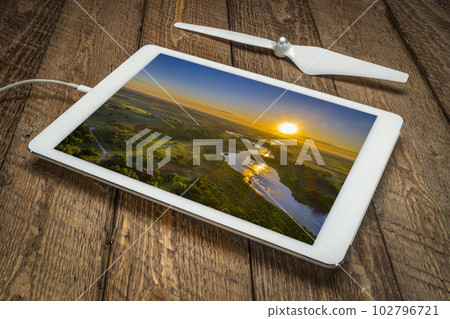 sunrise over Dismal River meandering through Nebraska Sandhills at Nebraska National Forest, reviewing a vacation image on a digital tablet 102796721