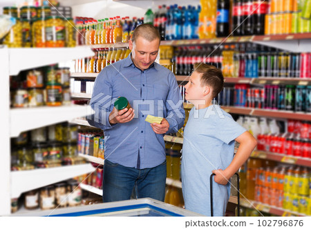 Father doing shopping with boy looking at shopping list Father doing shopping with boy looking at shopping list 102796876