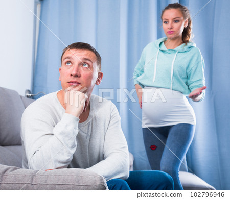 Husband and pregnant wife arguing at home 102796946