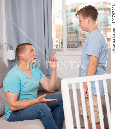 Adult male with his anxious son are resting together and talking about teenage secrets 102797528