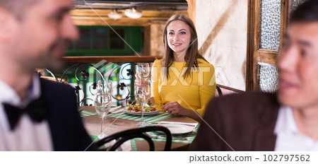 Woman is dining alone and carried away of talk two men 102797562