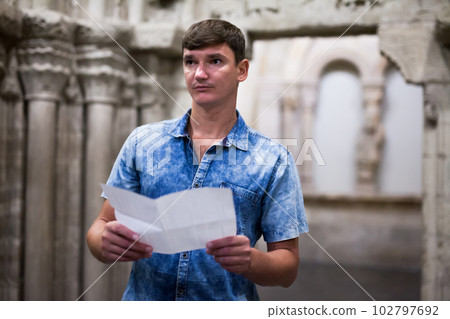 Man visiting museum with leaflet Man visiting museum with leaflet 102797692