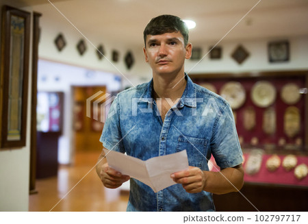 Man visiting museum with leaflet Man visiting museum with leaflet 102797717