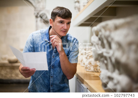 Man visiting museum with leaflet 102797743