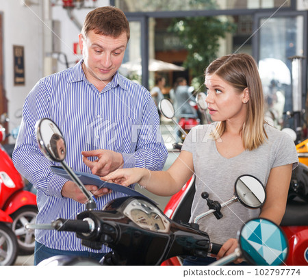 Couple is shopping and choosing new motobike 102797774