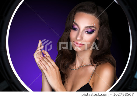 Female portrait of a young brunette girl with a beautiful evening make-up. Female portrait of a young brunette girl with a beautiful evening make-up. 102798507