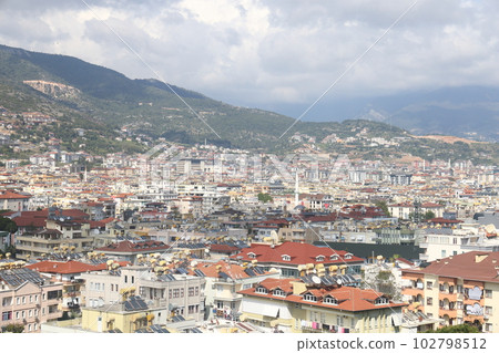 View of the highway, houses and mountains in Alanya orange groves. Evening time, Turkiye, April 2023 View of the highway, houses and mountains in Alanya orange groves. Evening time, Turkiye, April 2023 102798512