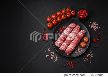 Raw minced meat wrapped in bacon with salt and spices or cevapcici Raw minced meat wrapped in bacon with salt and spices or cevapcici 102799049