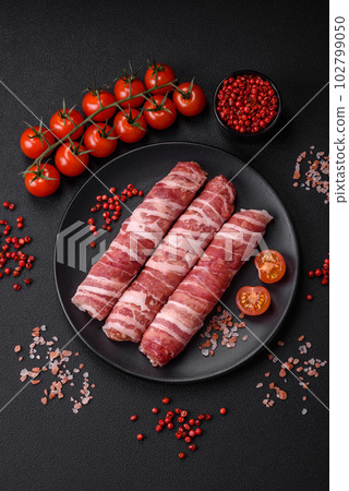 Raw minced meat wrapped in bacon with salt and spices or cevapcici Raw minced meat wrapped in bacon with salt and spices or cevapcici 102799050