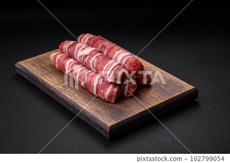 Raw minced meat wrapped in bacon with salt and spices or cevapcici 102799054
