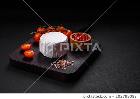 Delicious fresh brie cheese in the form of a mini head with cherry tomatoes 102799082