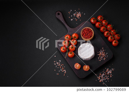 Delicious fresh brie cheese in the form of a mini head with cherry tomatoes 102799089