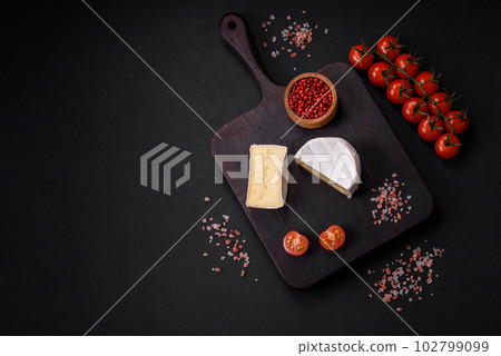 Delicious fresh brie cheese in the form of a mini head with cherry tomatoes Delicious fresh brie cheese in the form of a mini head with cherry tomatoes 102799099