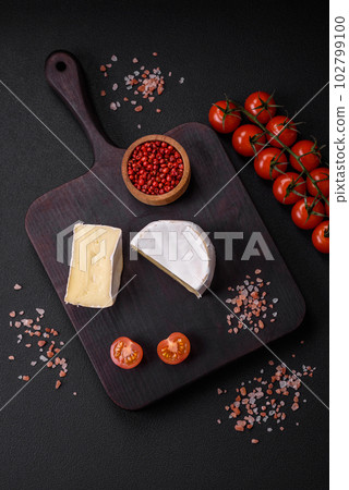 Delicious fresh brie cheese in the form of a mini head with cherry tomatoes Delicious fresh brie cheese in the form of a mini head with cherry tomatoes 102799100