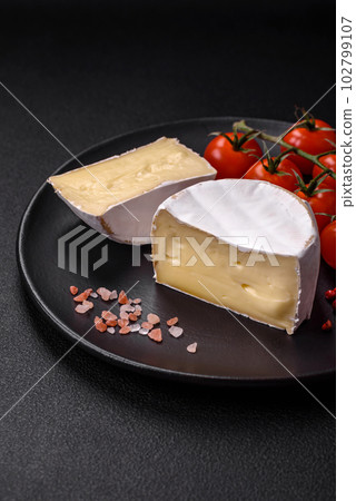 Delicious fresh brie cheese in the form of a mini head with cherry tomatoes 102799107