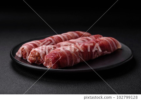 Raw minced meat wrapped in bacon with salt and spices or cevapcici 102799128