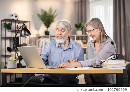 Mature freelancers studying contract on computer at home 102799869