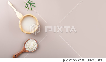 Homemade cosmetic rice water with ingredients and beauty kit on beige background, top view copy space, home spa flat lay 102800898